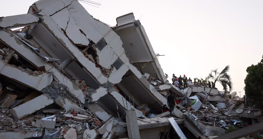 People search for survivors in the rubble of a collapsed building following an earthquake, in La Guaira, Venezuela,
