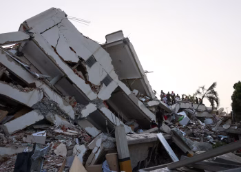 People search for survivors in the rubble of a collapsed building following an earthquake, in La Guaira, Venezuela,