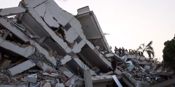 People search for survivors in the rubble of a collapsed building following an earthquake, in La Guaira, Venezuela,